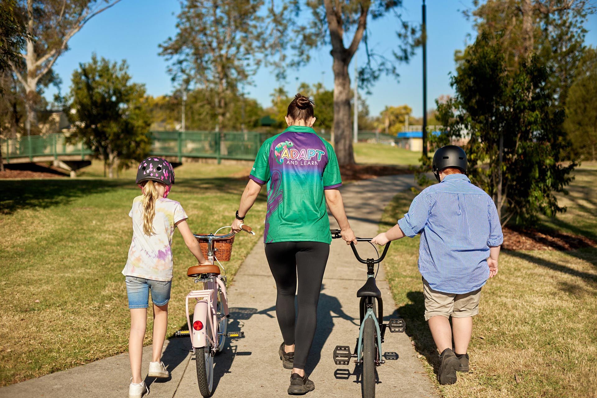 Occupational Therapist with 2 students holding their bikes