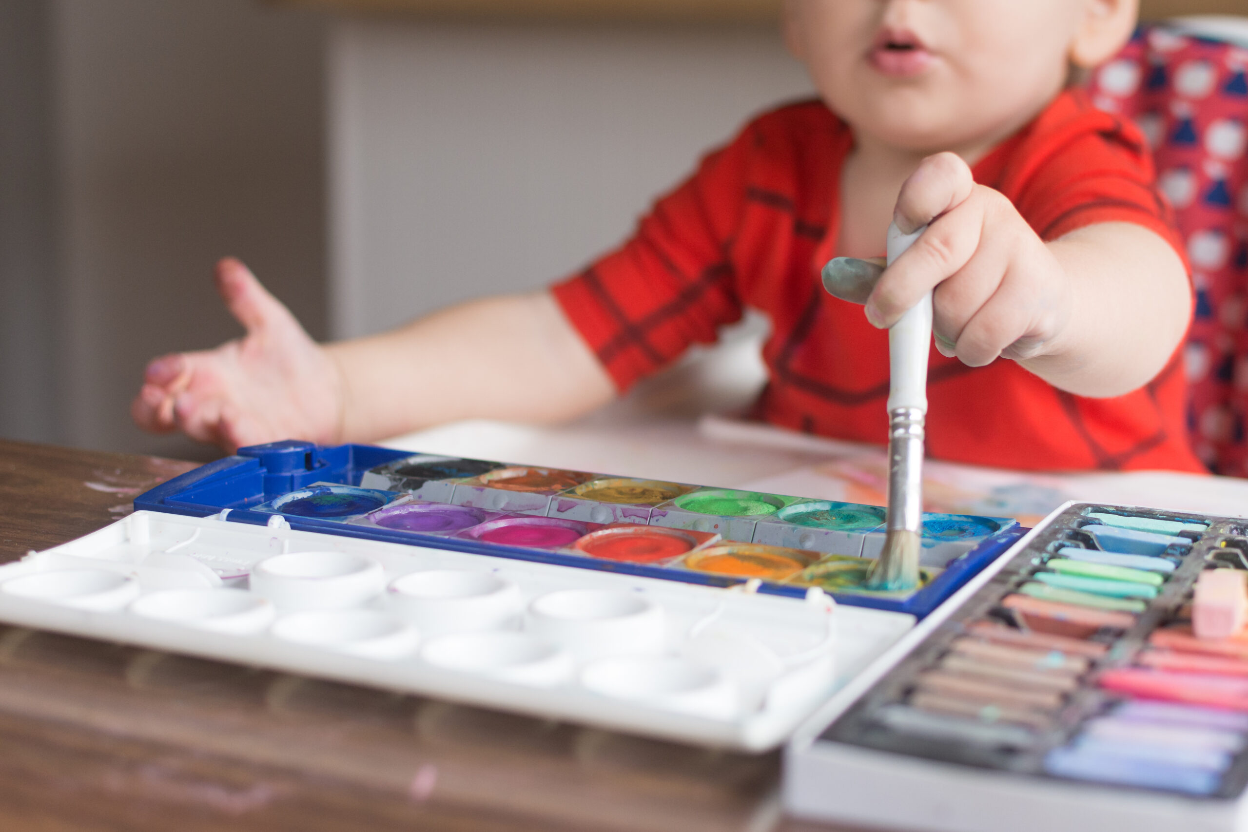 18 month old toddler makes excited expression while dipping pain